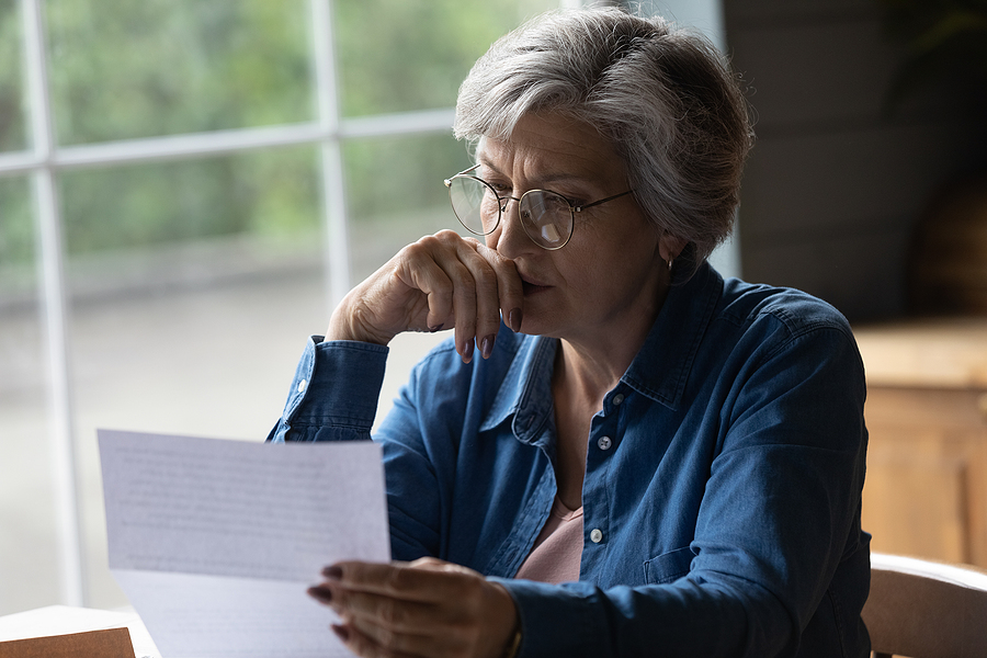 Middle aged female reading letter looking concerned, Managing Spousal Support